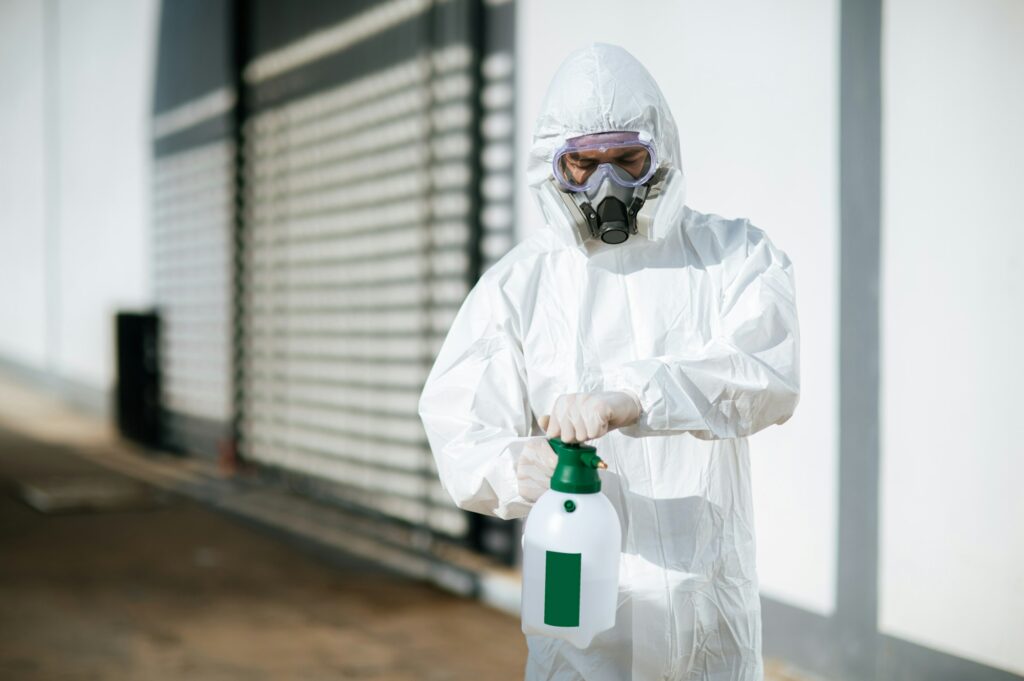 Disinfection specialist in PPE suit performing public decontamination