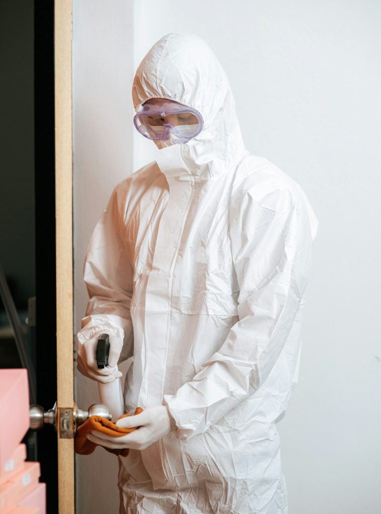 Disinfection specialist in PPE suit performing public decontamination
