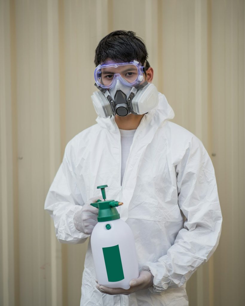 Disinfection specialist man in PPE suit performing public decontamination