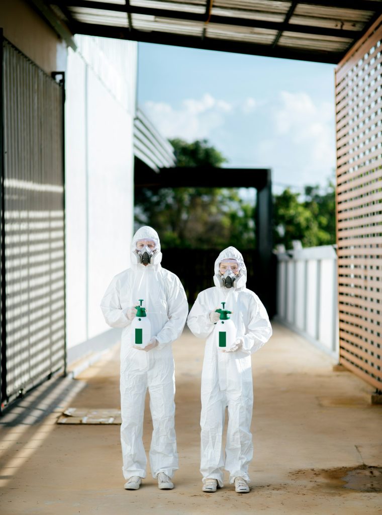 Disinfection specialist team in PPE suit performing public decontamination